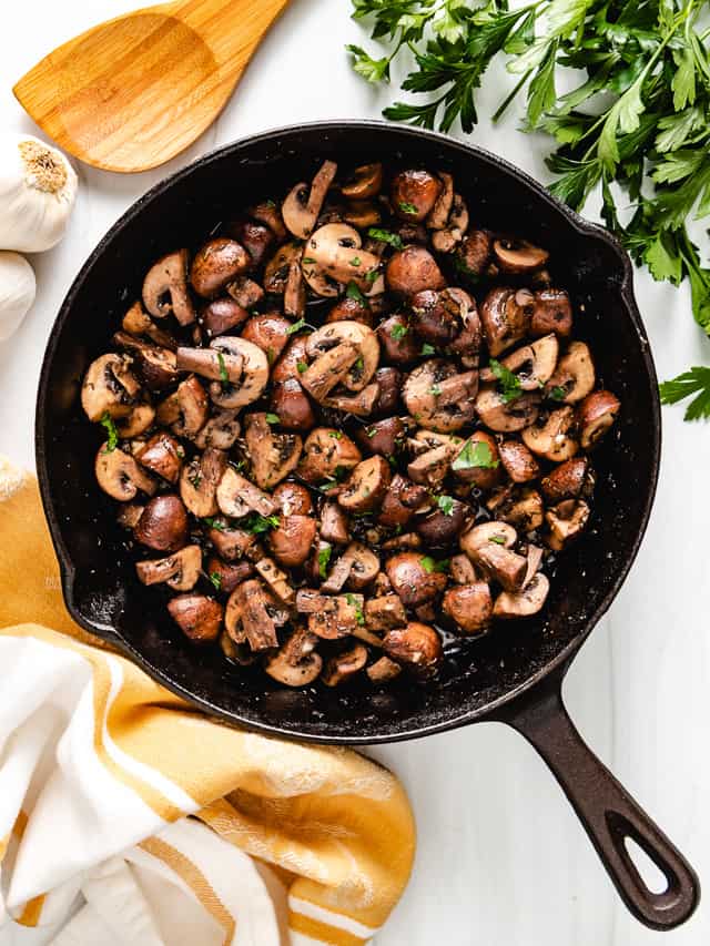 Top down view of seasoned mushrooms in a pan.