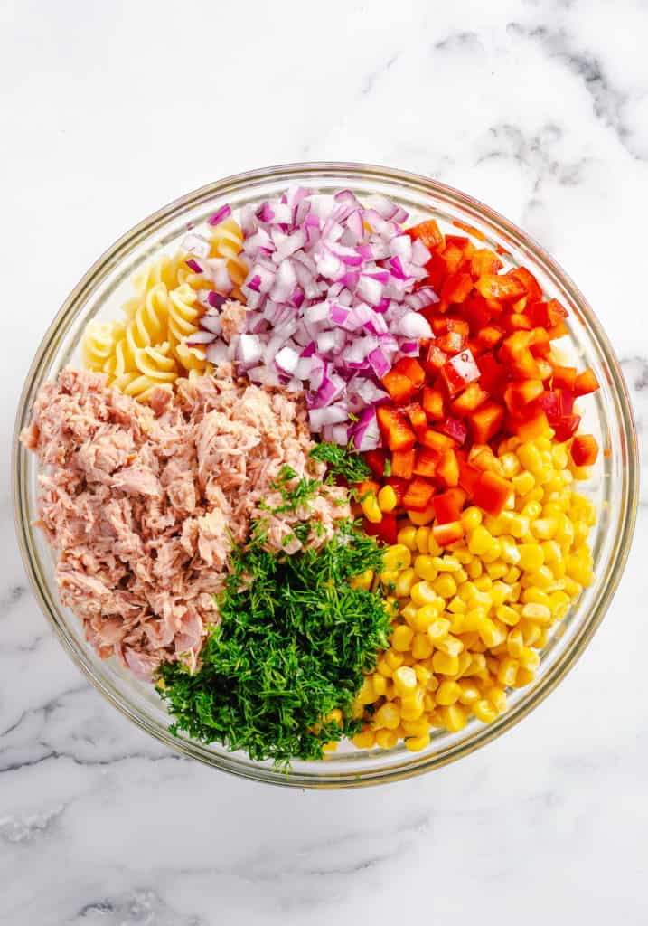 Tuna, noodles, peppers, onions and corn in a bowl.