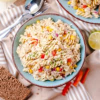 Top down view of a blue bowl filled with tuna pasta salad.