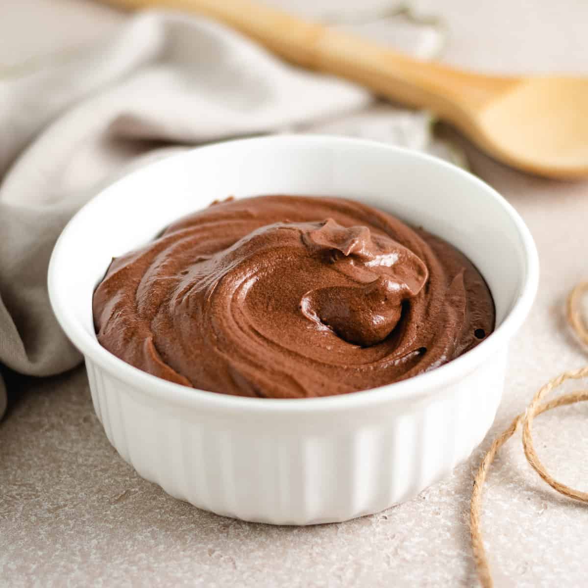 Chocolate Frosting White dish filled with frosting and a wooden spoon.