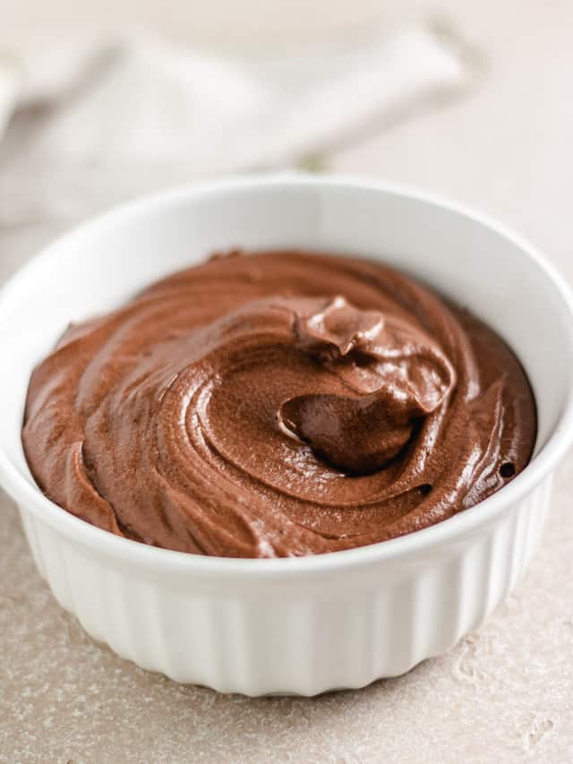 Large white dish filled with chocolate frosting.