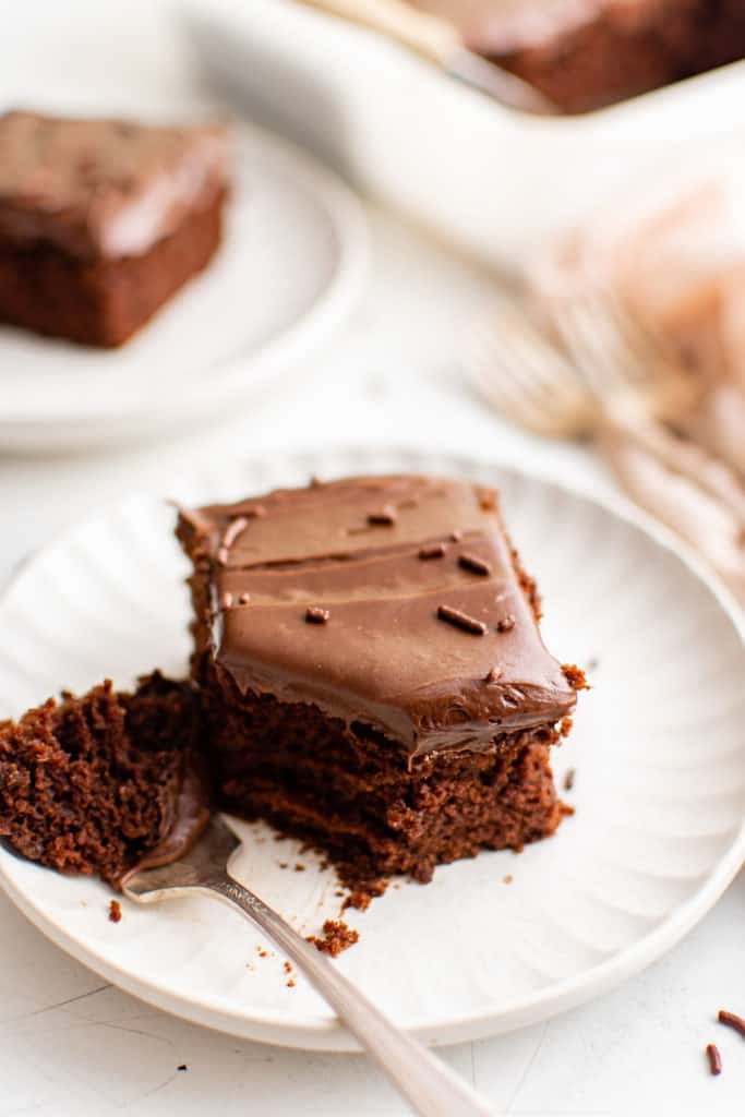 Chocolate cake with frosting next to a fork.
