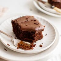 Slice of wacky cake with chocolate frosting on a plate.