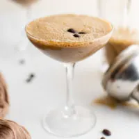 Espresso martini in a glass with coffee beans.