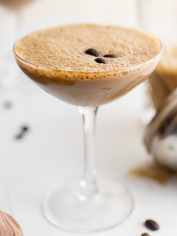 Espresso martini in a glass with coffee beans.