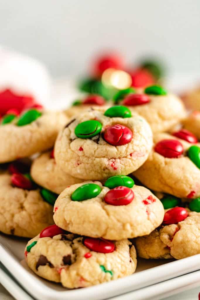 Pile of mini cookies with red and green candies.