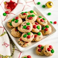 Square white plate piled with mini christmas cookies.