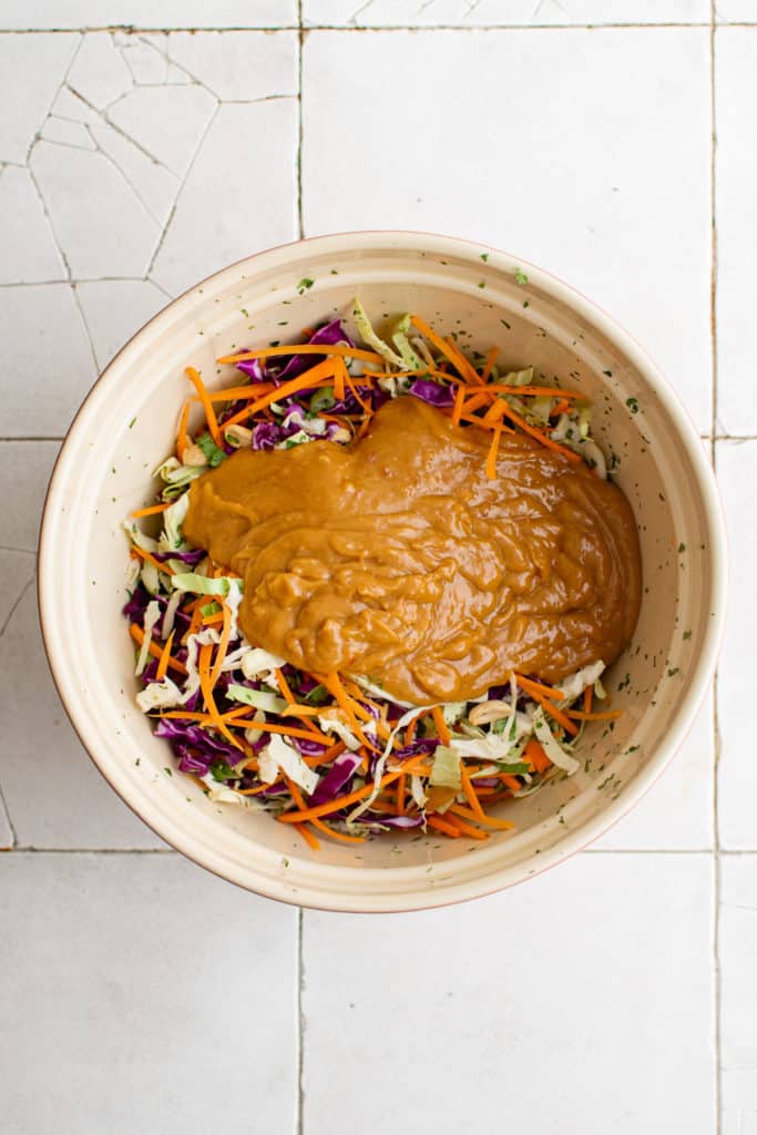 Top down view of salad with dressing in a bowl.