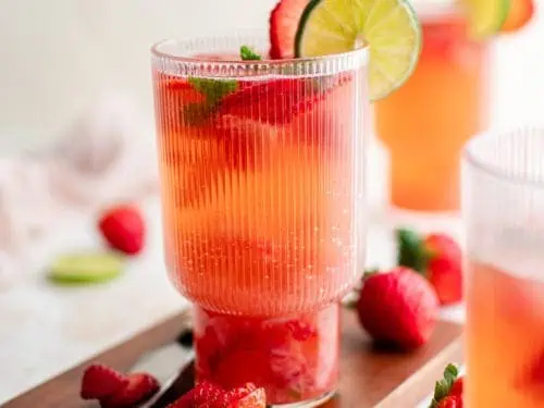 Glasses of strawberry mojito on a cutting board.