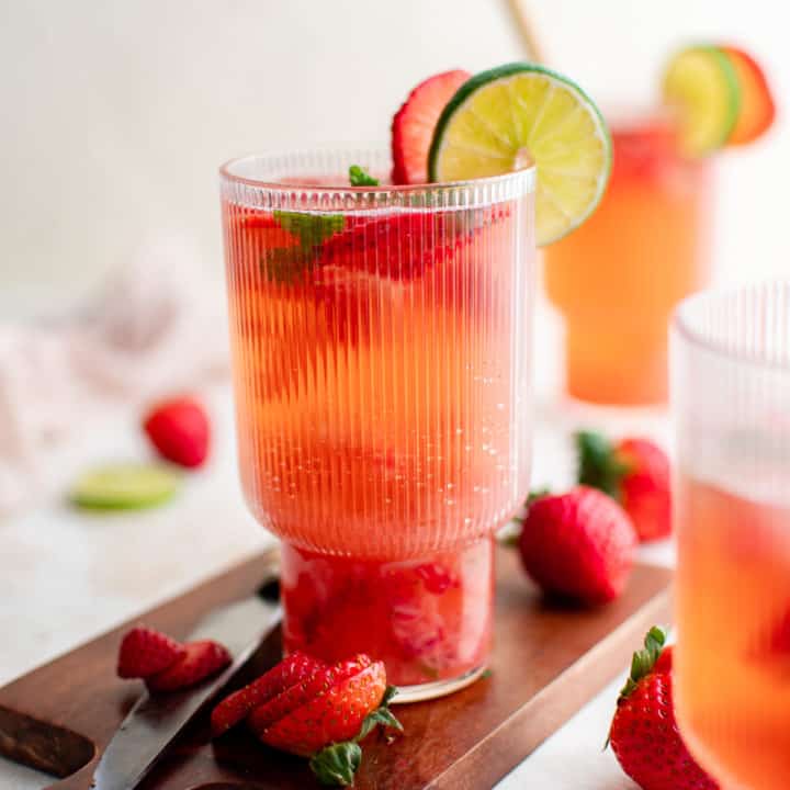 Glasses of strawberry mojito on a cutting board.