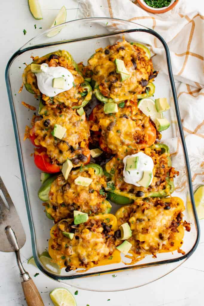 Top down view of stuffed bell peppers in a baking dish.