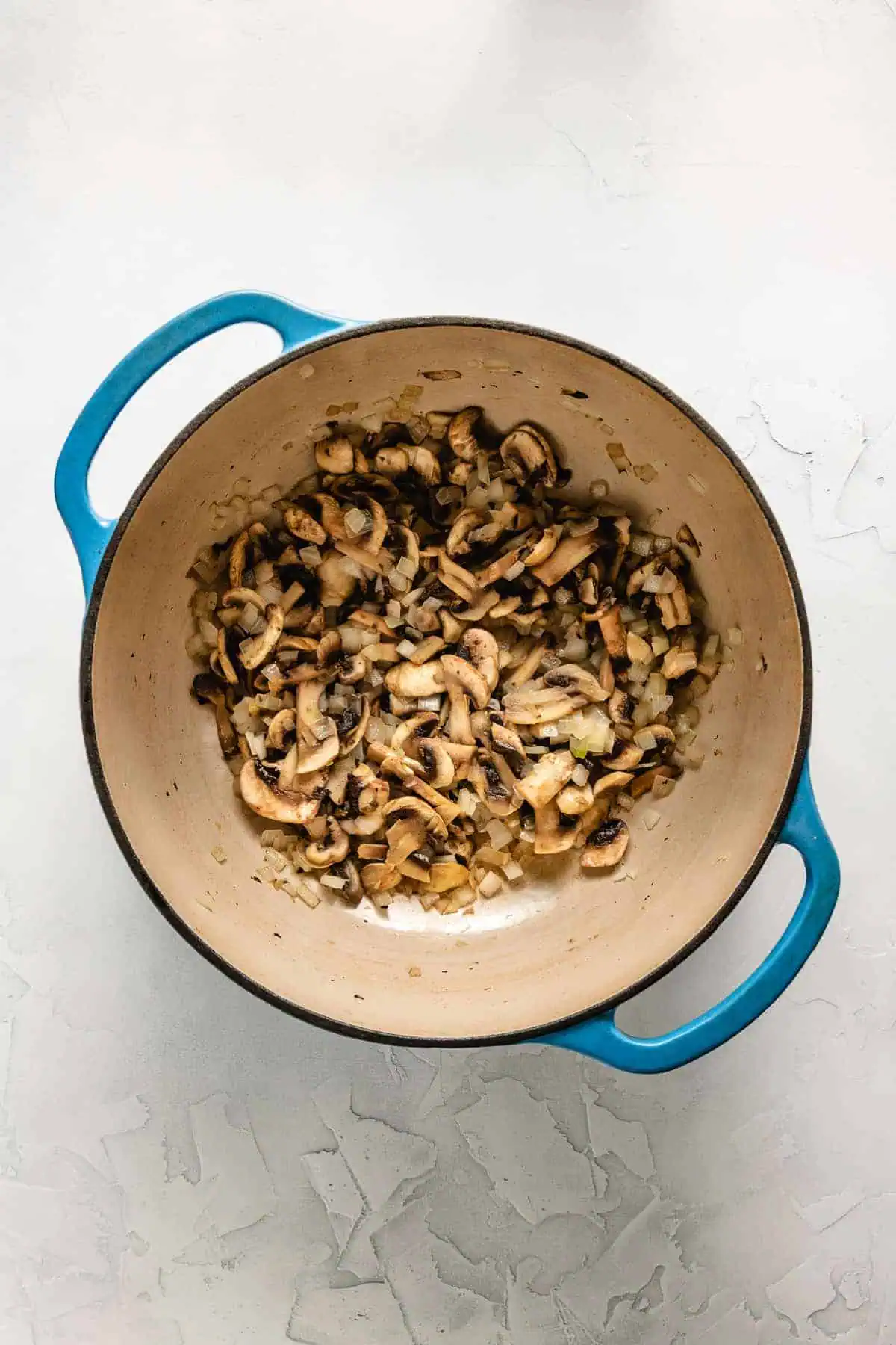Mushrooms and onions cooking in Dutch oven.