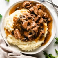 Top down view of beef tips and gravy on potatoes.