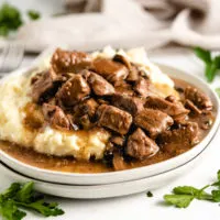 Mashed potatoes, gravy and beef tips on a plate.