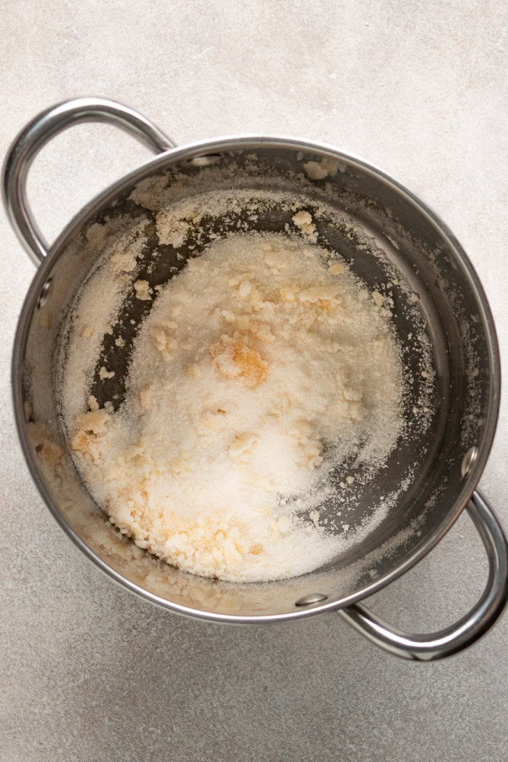Sugar beginning to melt in a pan.