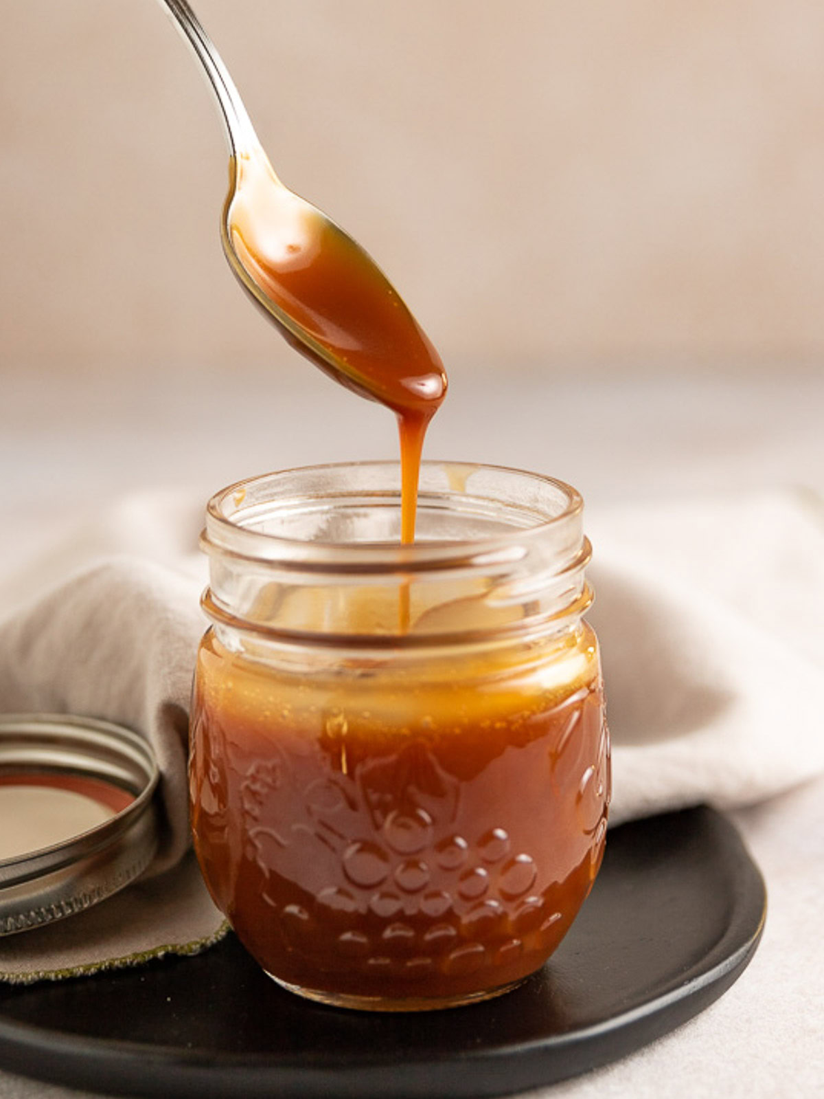 Spoon being dipped into caramel sauce.