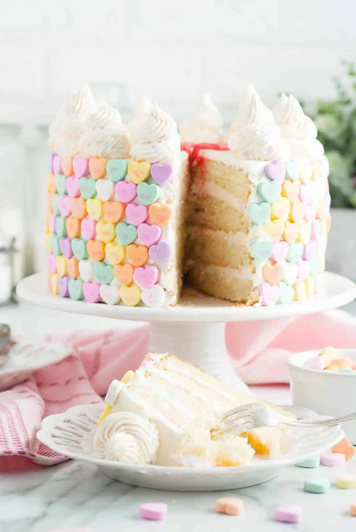 Piece of frosted white cake on a white plate.