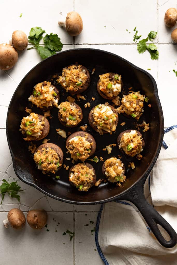 Top down view of crab stuffed mushrooms in cast iron.