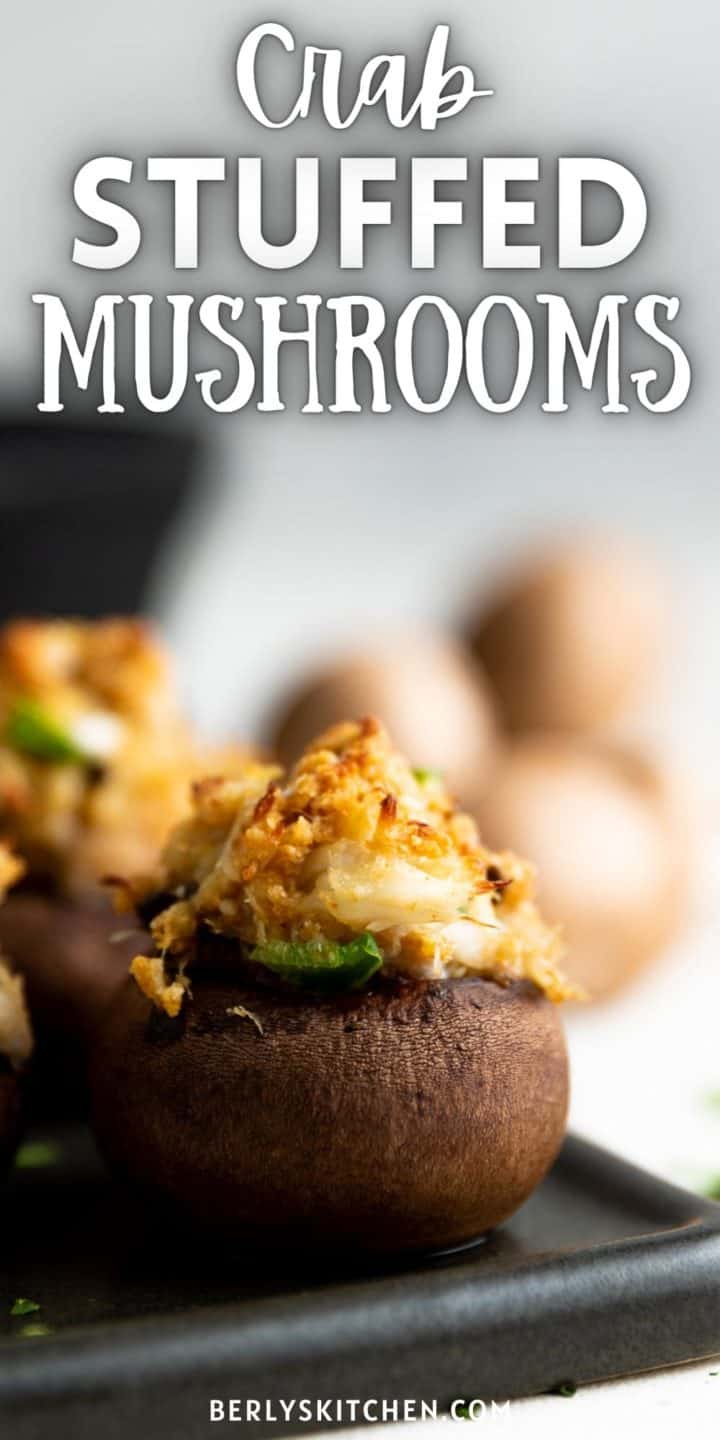 Crab stuffed mushrooms on a black platter.