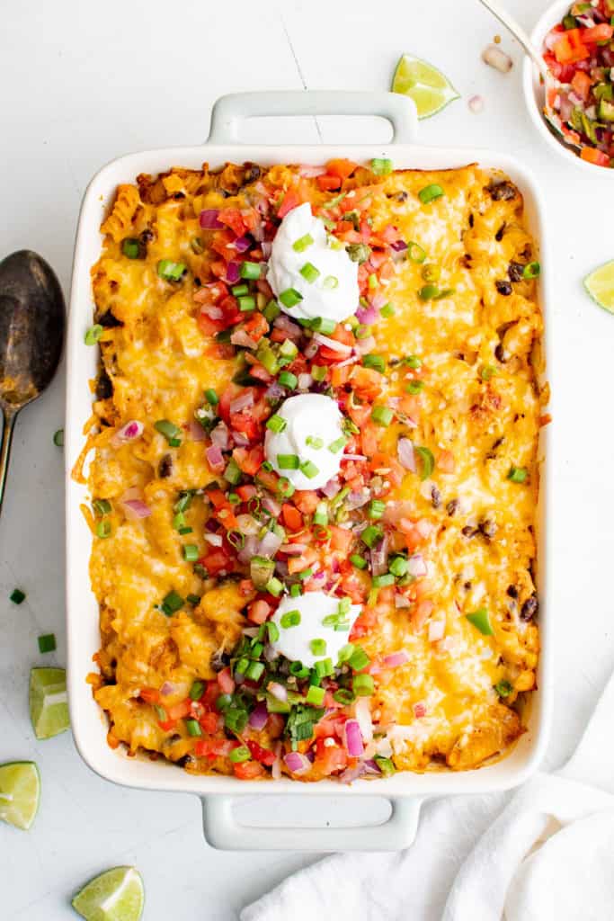 Top down view of sour cream and pico de gallo on top of casserole.