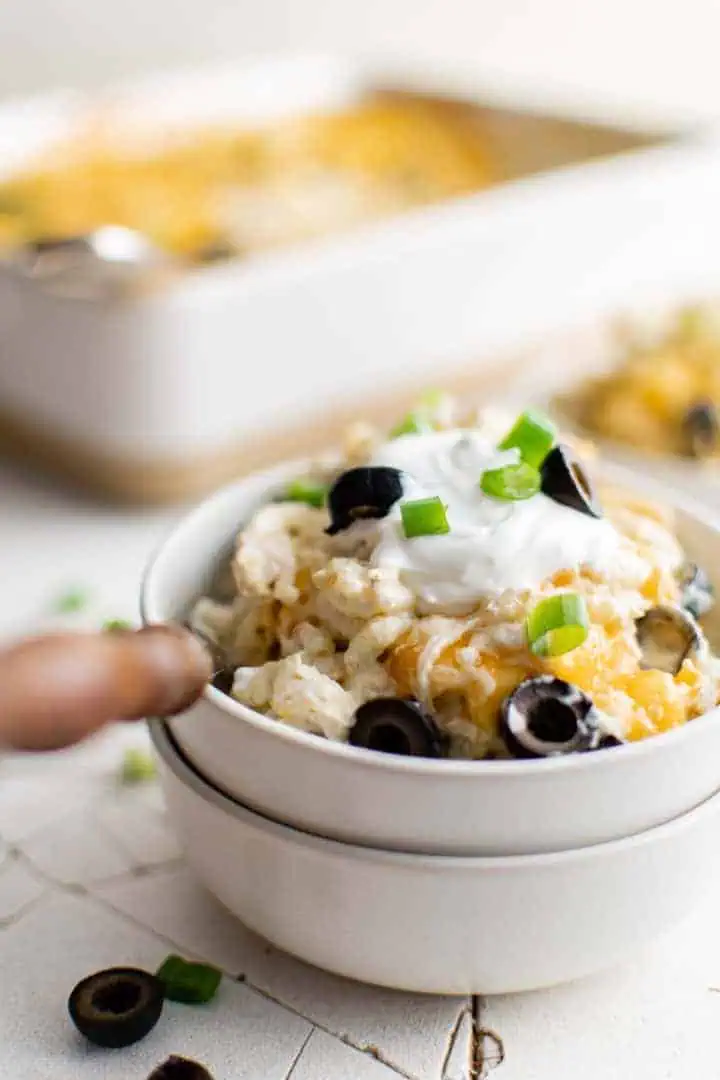 White bowls filled with green chile chicken casserole.
