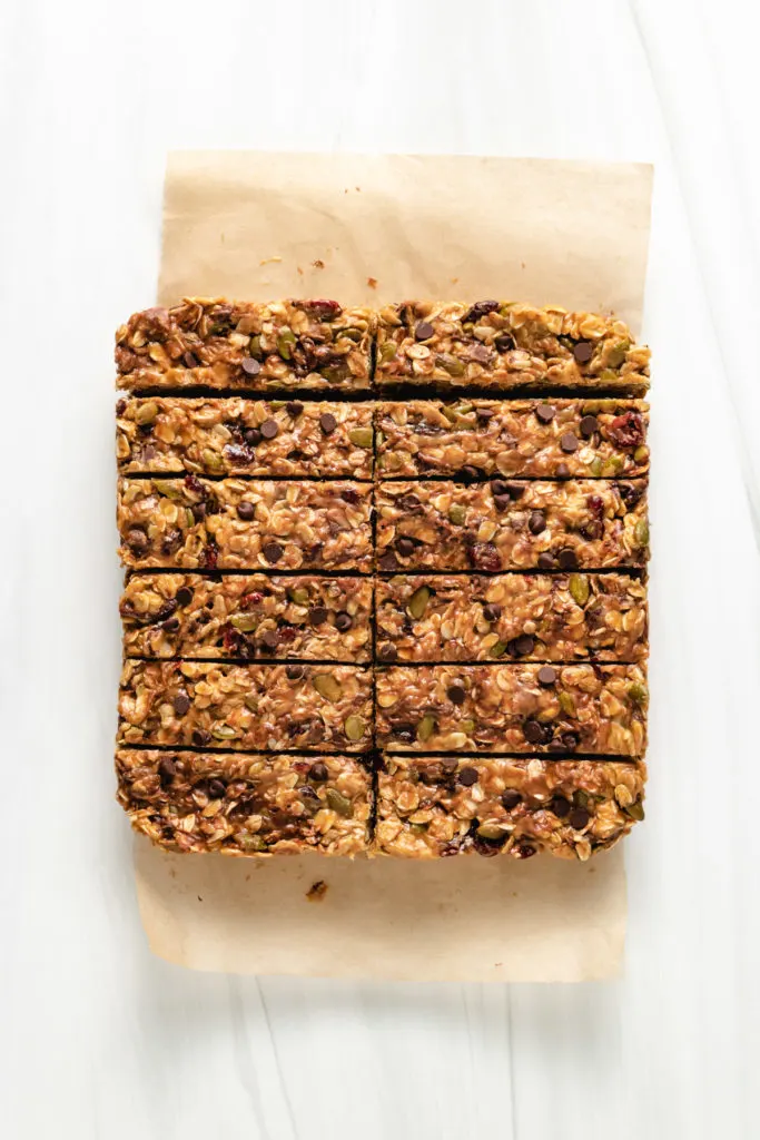 Top down view of a batch of homemade granola bars on brown paper.