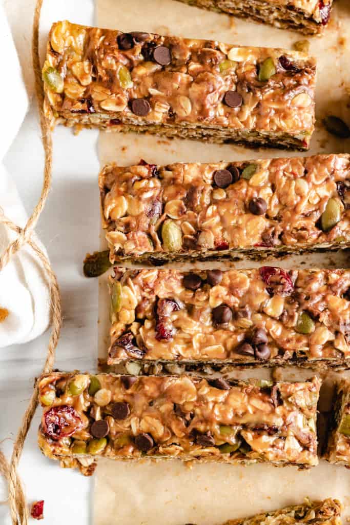 Top down view of several homemade granola bars on parchment paper.