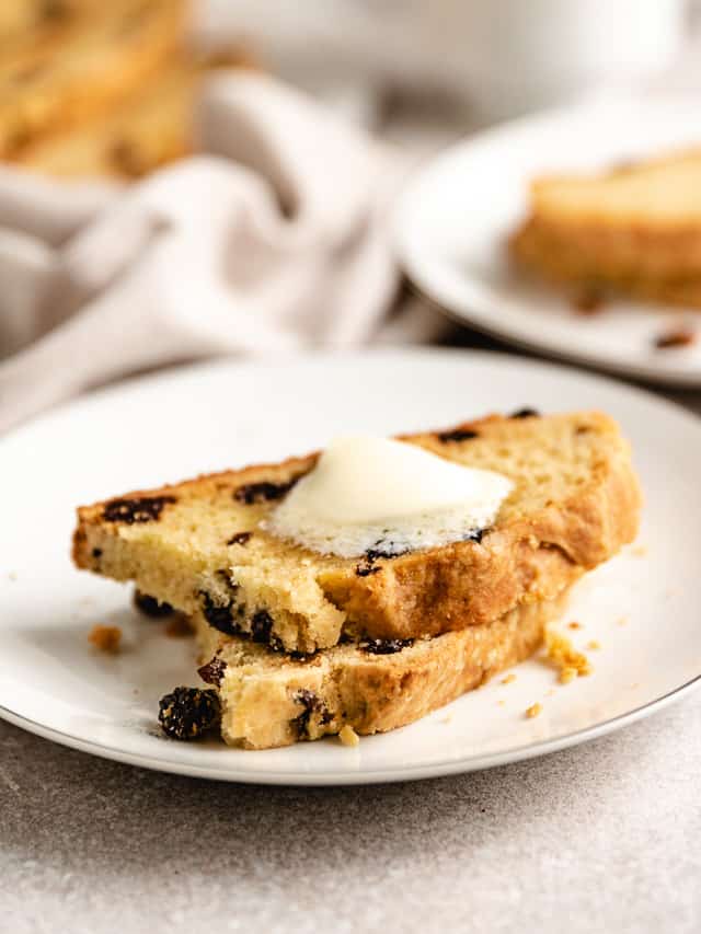 Two pieces of raisin Irish soda bread on a plate.