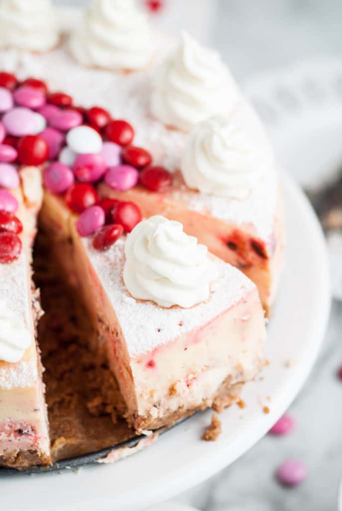 Sliced cheesecake on a cake stand.