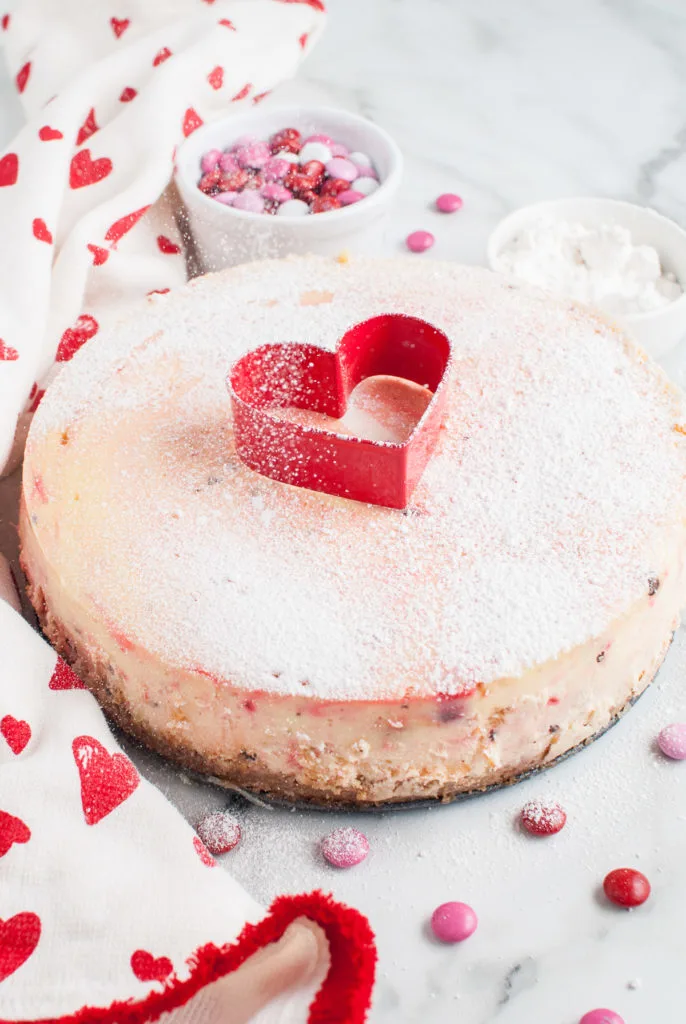 Cheesecake with a heart shaped cookie cutter on top.