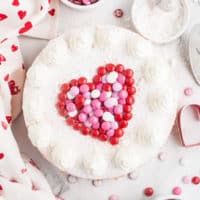 Top down view of a heart on top of an M&M cheesecake.