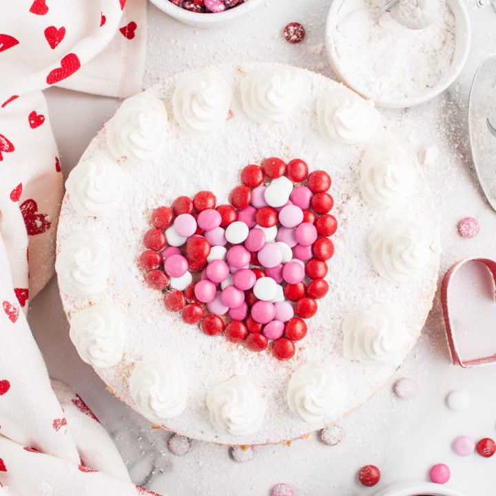 Top down view of a heart on top of an M&M cheesecake.