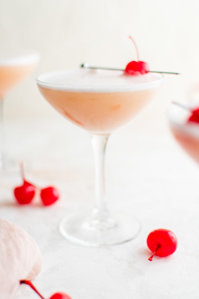 Several glasses filled with pink cocktail.