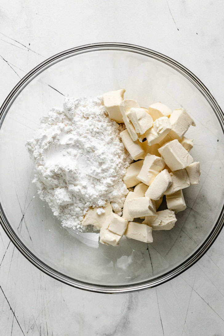 Cream cheese, powdered sugar, and vanilla in a bowl.