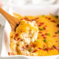 Scoop of mashed potato casserole on a wooden spoon.