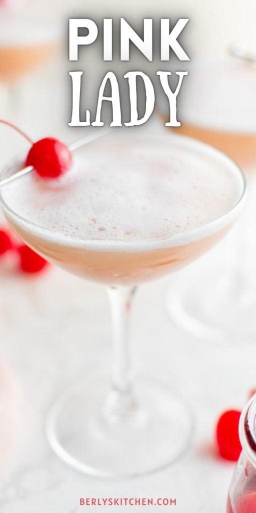 Close up of a pink lady cocktail with a cherry.