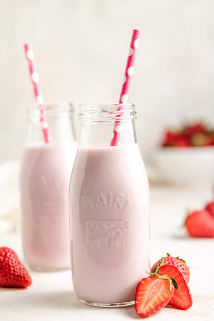 Close up view of pink flavored milk in jars.