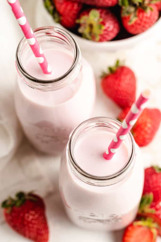 Top down view of twos jars of strawberry milk.