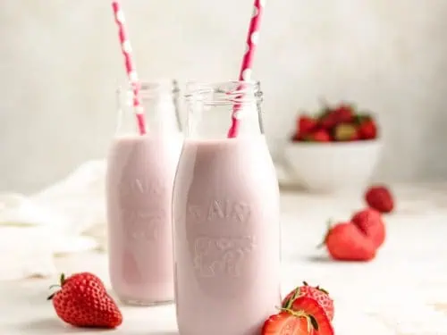 Two jars of strawberry milk.