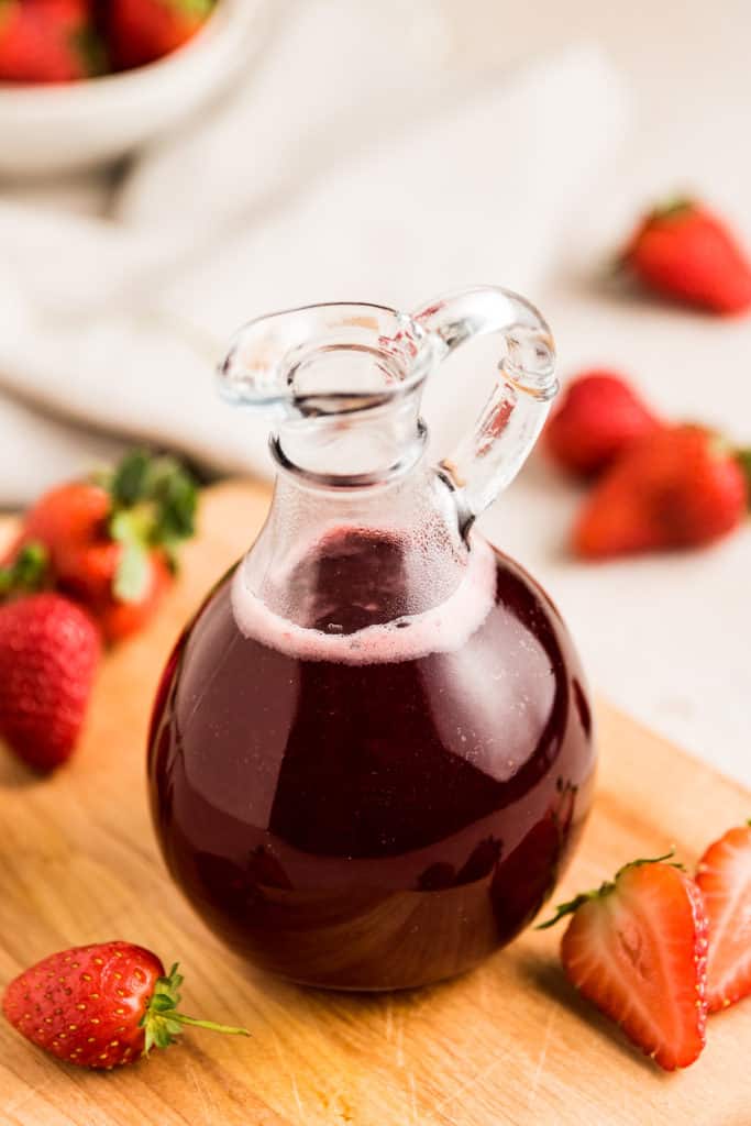 Close up view of strawberry syrup in a bottle.