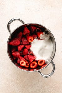 Strawberries, sugar, and water in a pan.