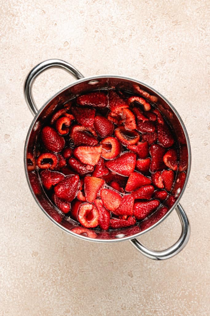 Softened strawberries and sugar in a pan.