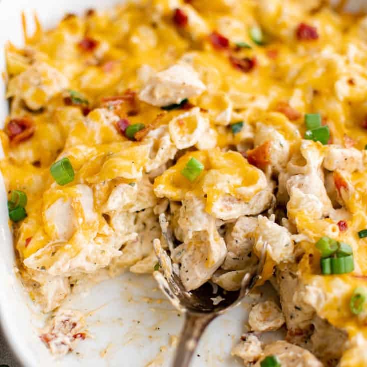 White casserole dish filled with chicken, bacon, and cheese.