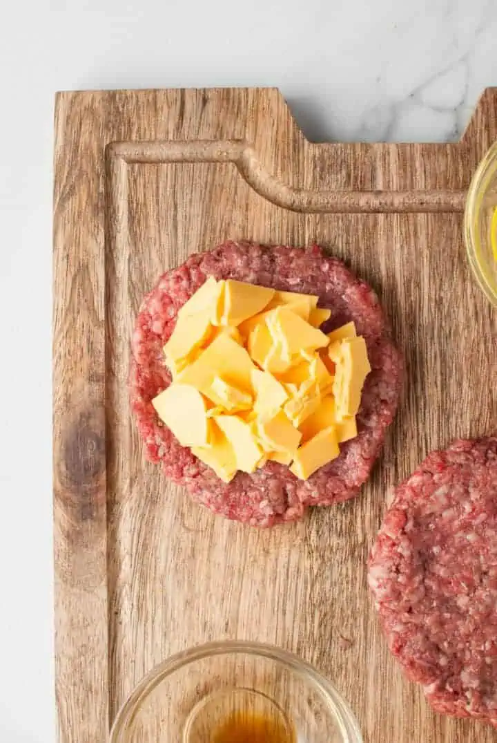Close up of a ground beef patty topped with cheese.