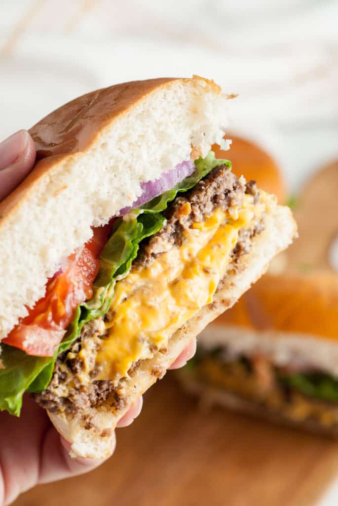 Hand holding a juicy lucy burger.