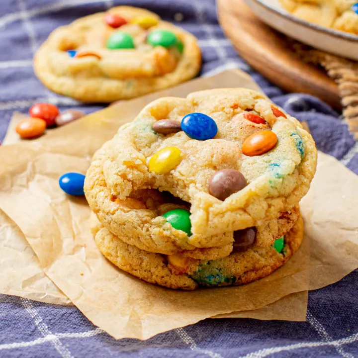 Stack of M&M cookies on parchment.