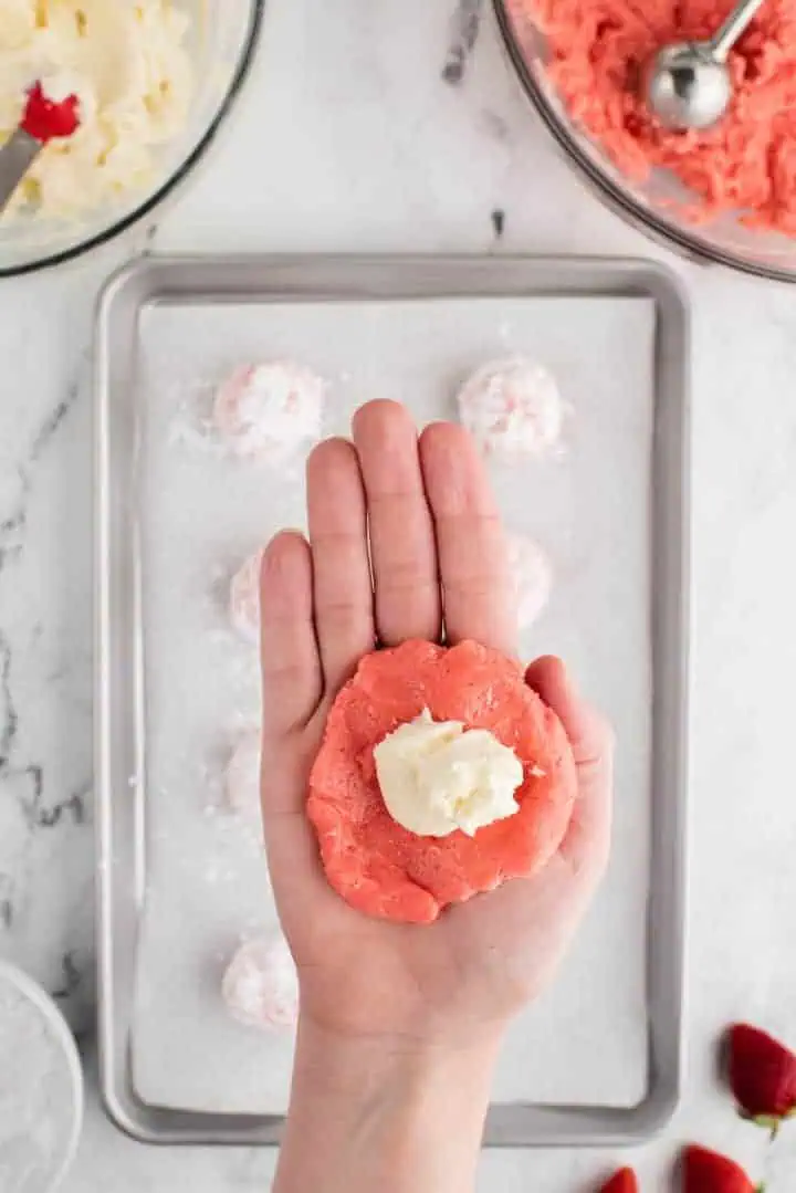 Cream cheese in the center of strawberry cookie dough.