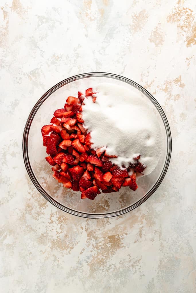 Sugar and strawberries in a dish.