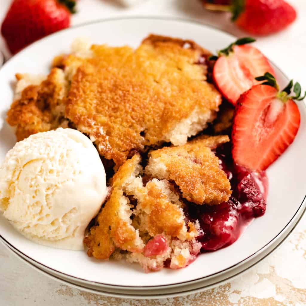 Top down view of strawberry cobbler on a plate.