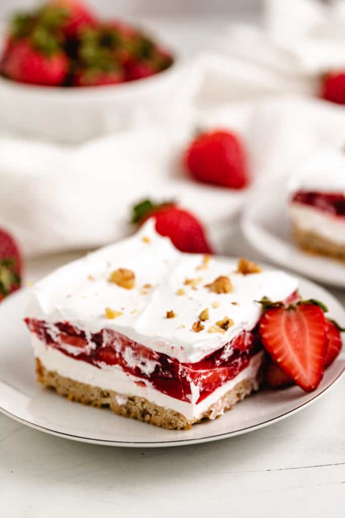 Slice of strawberry dessert on a white plate.
